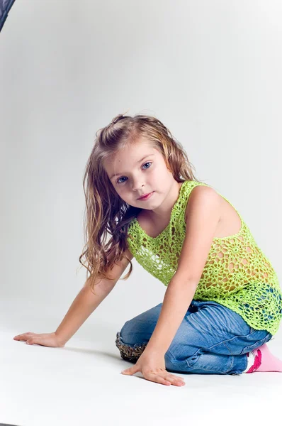 Krásná holčička s skladování oblečení a džíny studi — Stock fotografie
