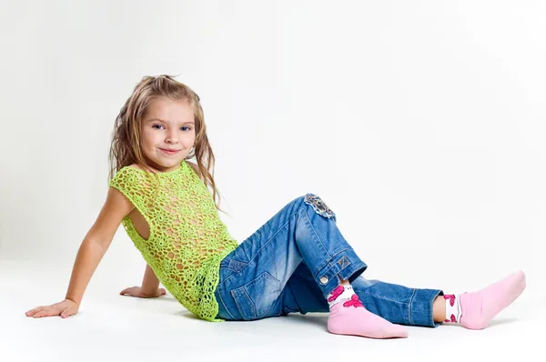 Vacker liten flicka med strumpan kläder och jeans i en studi — Stockfoto
