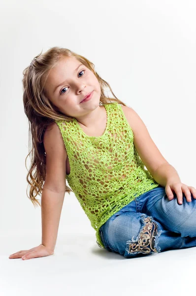 Krásná holčička s skladování oblečení a džíny studi — Stock fotografie