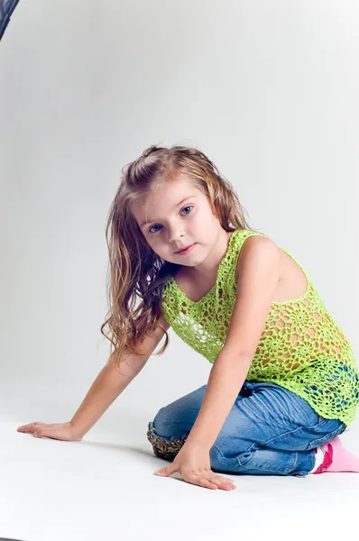 Krásná holčička s skladování oblečení a džíny studi Stock Fotografie