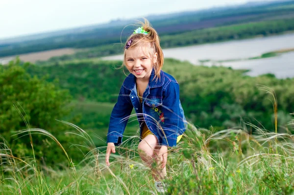 Güzel küçük bir kız açık havada yürüyüşe jean giysiler — Stok fotoğraf