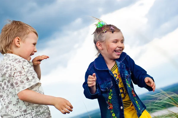 Маленькая девочка и мальчик играют и болеют на прогулке на открытом воздухе — стоковое фото