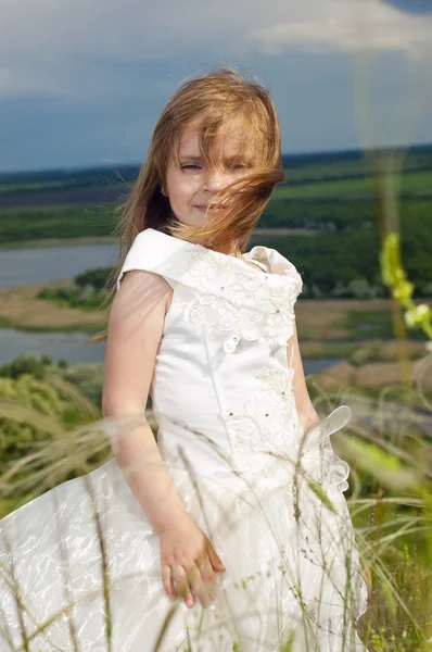 Девушка в одежде невесты на поле с фотоаппаратом — стоковое фото
