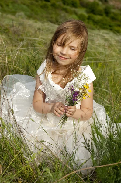 Belle fille dans les vêtements de mariée sur le terrain avec le fie — Photo