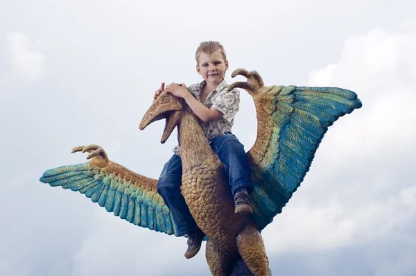 Little brave boy on a dinosaur in a park — Stock Photo, Image