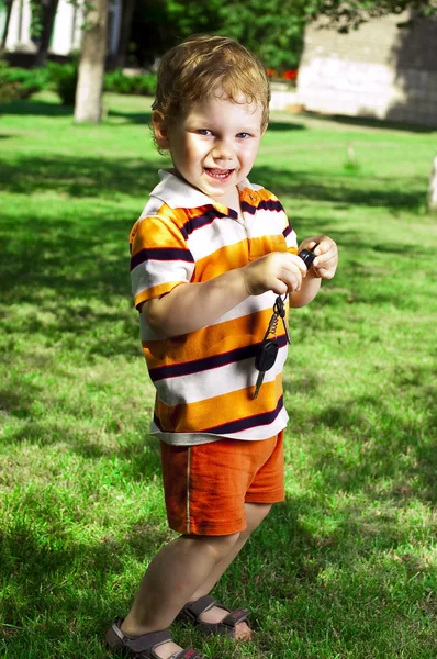 Kleine jongen is in de zomer op een gazon — Stockfoto