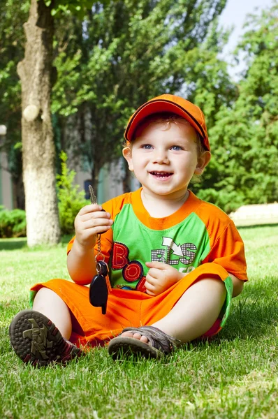 Liten pojke är sommaren på en gräsmatta — Stockfoto