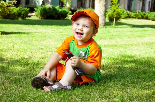 小さな男の子は夏の芝生の上で — ストック写真