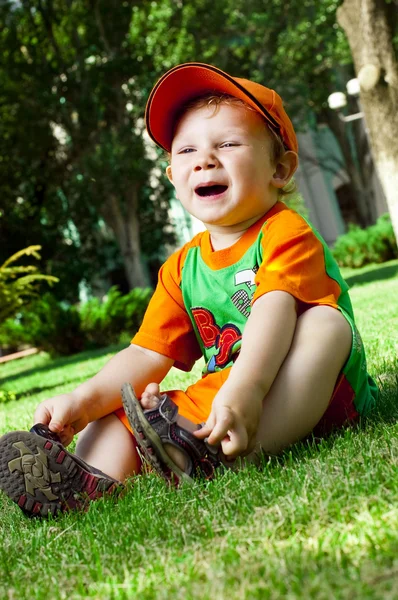 Liten pojke är sommaren på en gräsmatta — Stockfoto