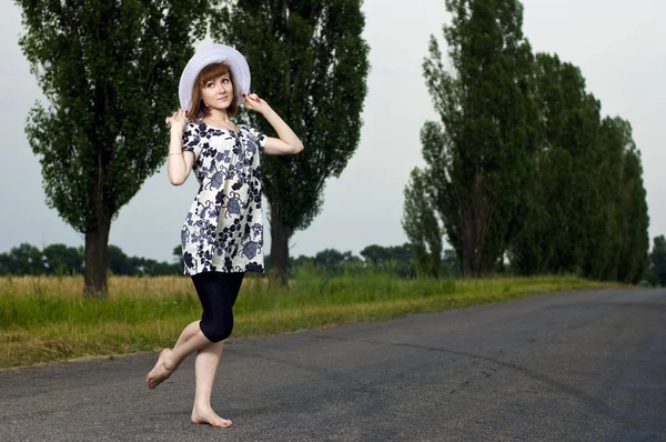 Красивая молодая девушка сидит в шляпе на открытом воздухе — стоковое фото