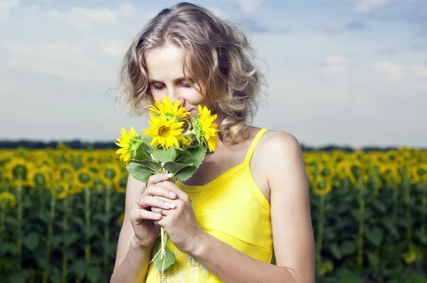 Slunce mladá dívka v poli se slunečnicemi — Stock fotografie