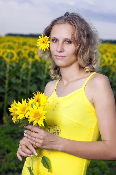 Slunce mladá dívka v poli se slunečnicemi — Stock fotografie