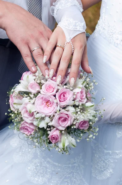 Boeket van inschrijving roses, handen en ringen van het huwelijk — Stockfoto