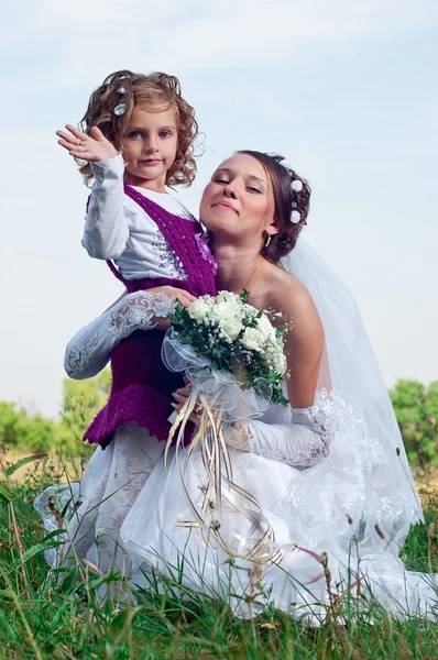 Wonderful young bride and beautiful little girl outdoors — Stock Photo, Image