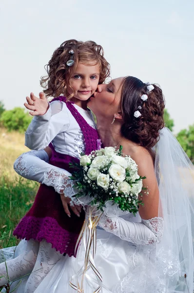 Nádherné mladá nevěsta a krásná holčička venku — Stock fotografie