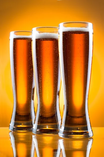 Üç bardak bira Sarı zemin üzerinde — Stok fotoğraf