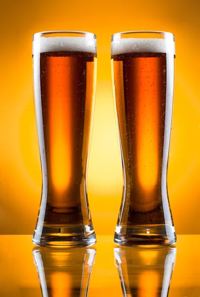 Két üveg sört, mint sárga háttérrel — Stock Fotó