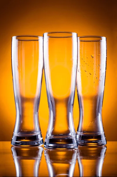 Trzy szklanki pustą szklankę do piwa i napojów na żółty backgro — Zdjęcie stockowe