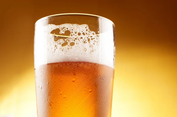 Glas öl med skum på nära håll — Stockfoto