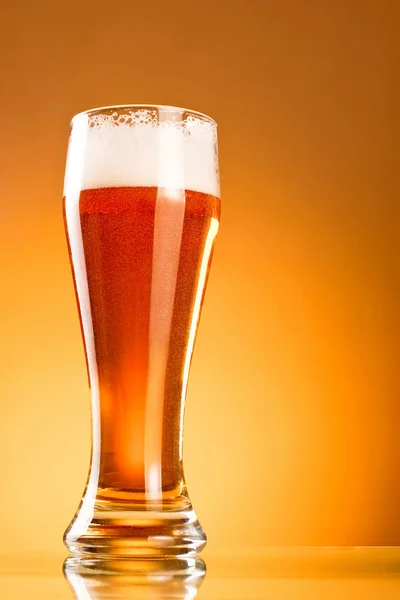 Glass of beer on a yellow background — Stock Photo, Image