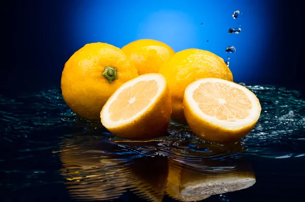 Bütün taze limon ve su bir na üzerinde bir yansıması ile yarıya indirir — Stok fotoğraf