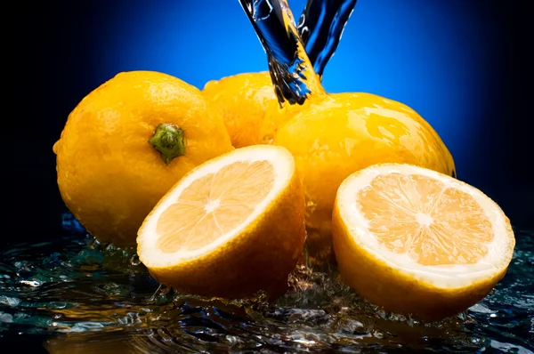 Bütün taze limon ve su bir na üzerinde bir yansıması ile yarıya indirir — Stok fotoğraf