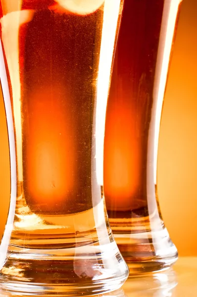 Parte inferior de duas cervejas de vidro sobre fundo amarelo — Fotografia de Stock