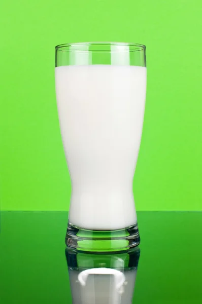 Un vaso de leche fresca sobre un fondo verde oscuro —  Fotos de Stock