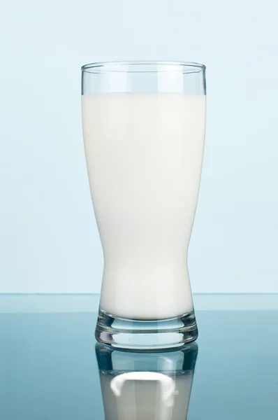 Copo de leite fresco em um fundo ciano escuro — Fotografia de Stock