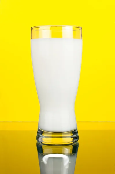 一杯新鲜的牛奶暗黄色背景上 — 图库照片