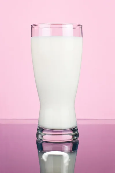 Glas färsk mjölk på en rosa bakgrund — Stockfoto