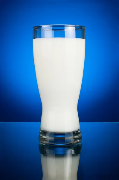 Verre de lait frais sur fond bleu foncé — Photo
