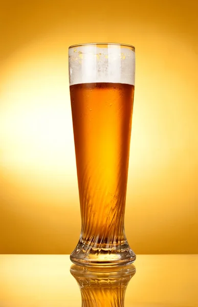 Egy pohár sör sárga alapon — Stock Fotó