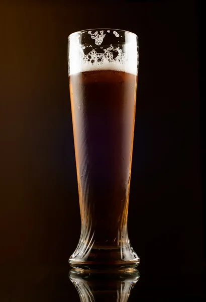 Vaso de cerveza oscura sobre fondo negro — Foto de Stock