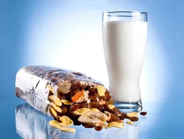 stock image Fresh Glass of Milk and Opened Pack of muesli on a blue backgrou