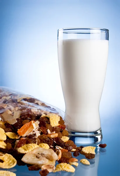 Fresh Glass of Milk and Closed Pack of muesli on a blue backgrou — Stock Photo, Image