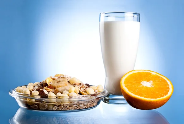 Dish of muesli, glass of fresh milk and Half of juicy orange on — Stock Photo, Image