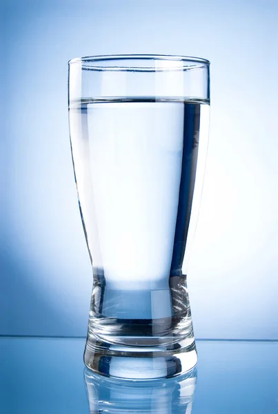 Glass of water on a blue background — Stock Photo, Image