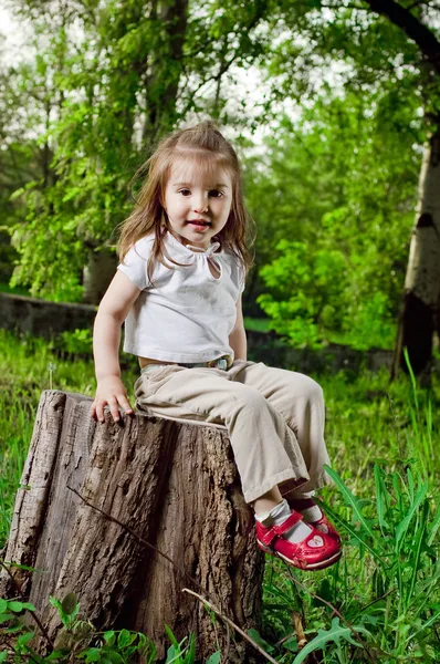 Забавная маленькая девочка сидит на конопле — стоковое фото