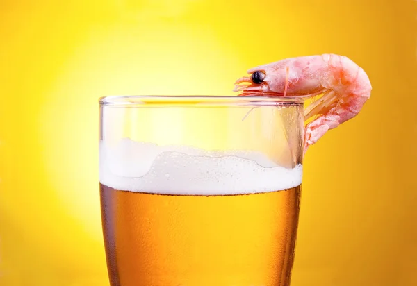 Cooked Shrimp in a glass of beer with foam on a yellow backgroun — Stock Photo, Image