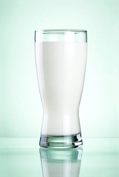 Glas van verse melk op groene achtergrond — Stockfoto