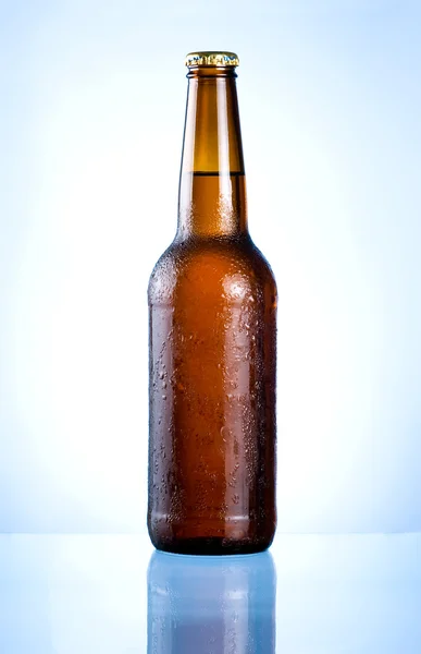 Volledige bruine fles met condensatie op een blauwe achtergrond — Stockfoto