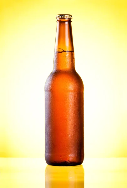 Brown garrafa cheia de cerveja fresca gelada coberta com condensado no yel — Fotografia de Stock