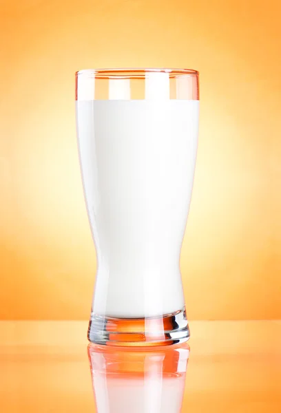 Vaso de leche sobre fondo naranja — Foto de Stock