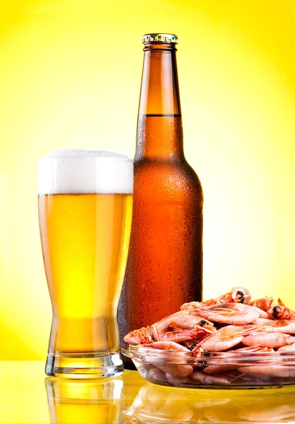 Brown bottle of beer with a condensate, a glass and a plate of b — Stock Photo, Image