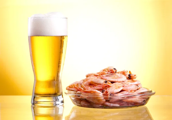 One glass of beer and cooked shrimp on a plate on a yellow backg — Stock Photo, Image
