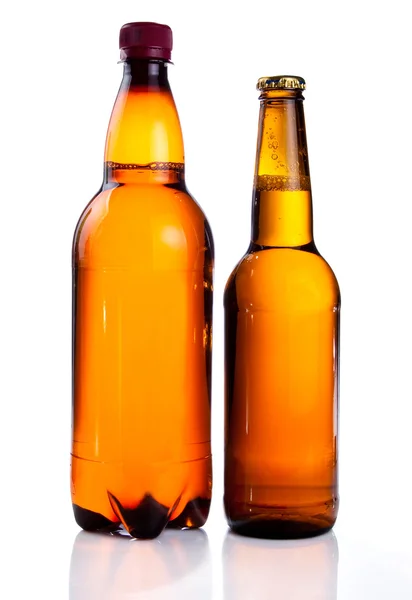 Isolierte braune Plastikflasche und Glasflasche Bier auf weißem Grund lizenzfreie Stockbilder