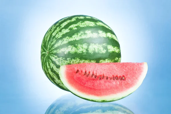 Mogen vattenmelon och skiva isolerad på en blå bakgrund — Stockfoto