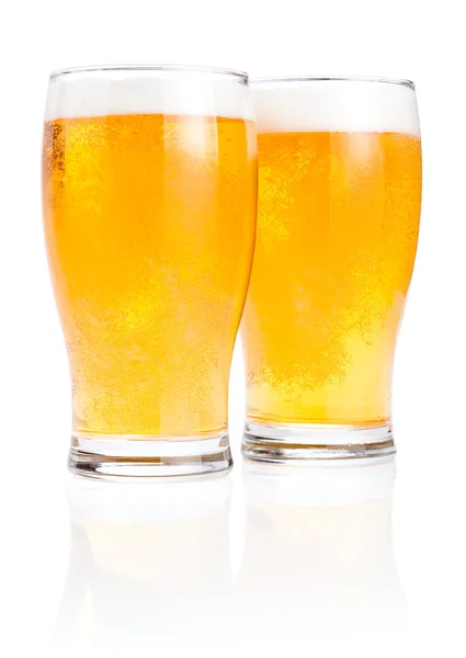 Due bicchieri di birra lager fresca con schiuma isolata su dorso bianco — Foto Stock
