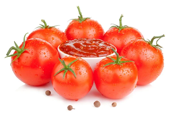 Чаша со свежим кетчупом и шесть мокрых сочных томатов изолированы — стоковое фото
